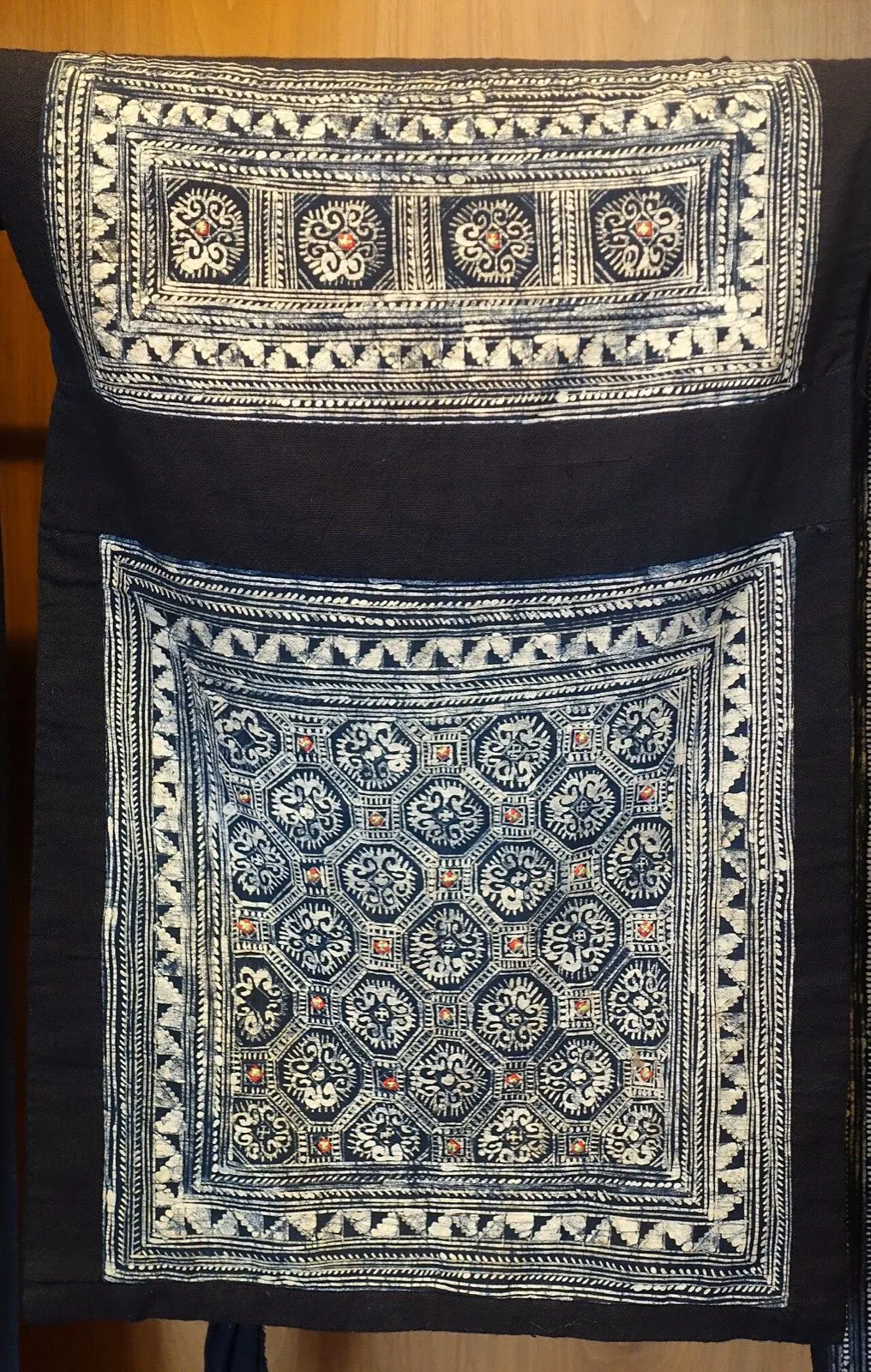 A Hmong baby carrier of indigo batik cloth with embroidered panels