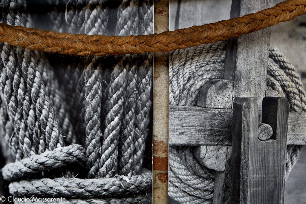Coils of rope, a wooden rope-making tool and a thick twisted rope displayed at Carmagnola's hemp museum.