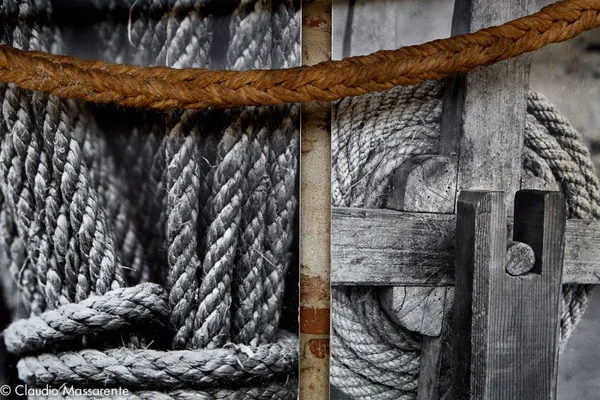 Coils of rope, a wooden rope-making tool and a thick twisted rope displayed at Carmagnola's hemp museum.