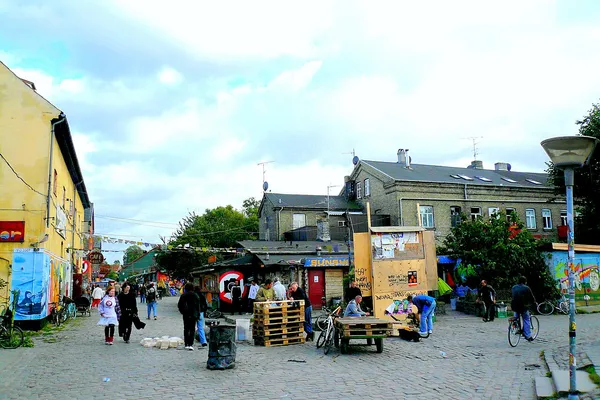 A cobbled street in Christiania lined with stalls and old buildings