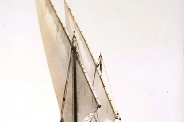 Historical photograph of a traditional Maltese wooden sailing boat with tall lateen sails and extensive rigging, photographed in Malta in the early twentieth century.