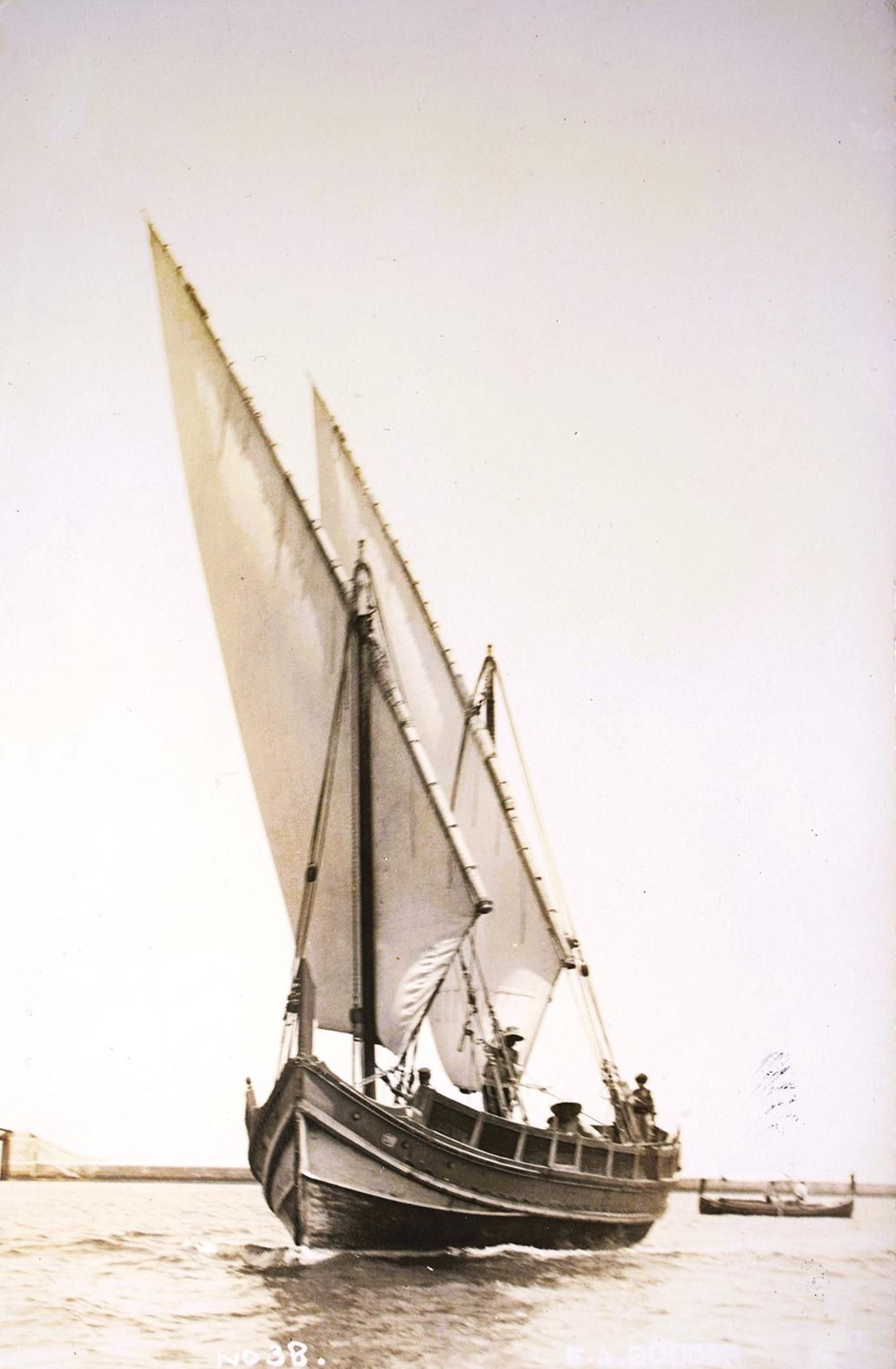 Historical photograph of a traditional Maltese wooden sailing boat with tall lateen sails and extensive rigging, photographed in Malta in the early twentieth century.