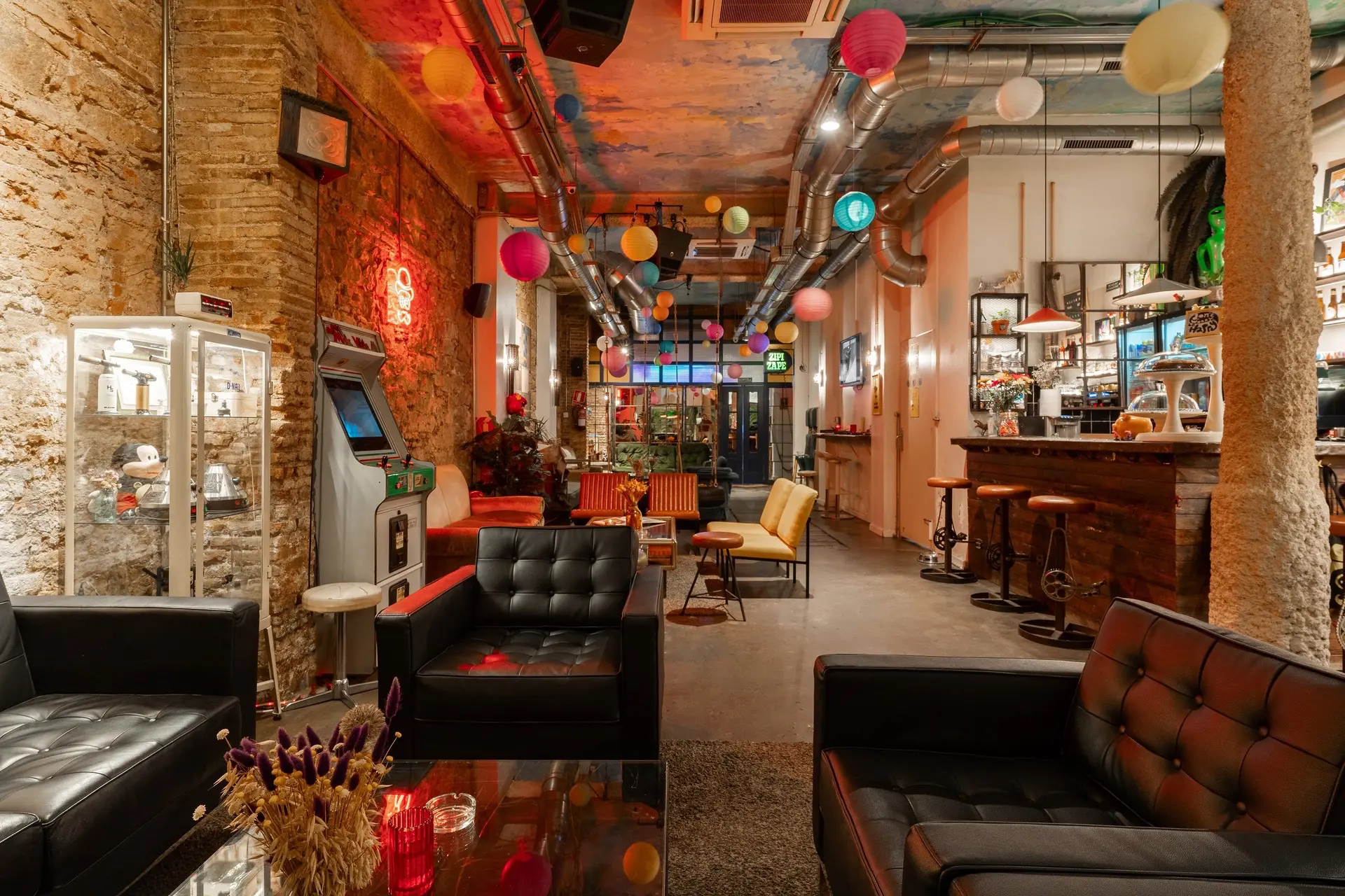 The lounge of a cannabis social club, with leather armchairs, exposed brick, coloured lanterns and a bar