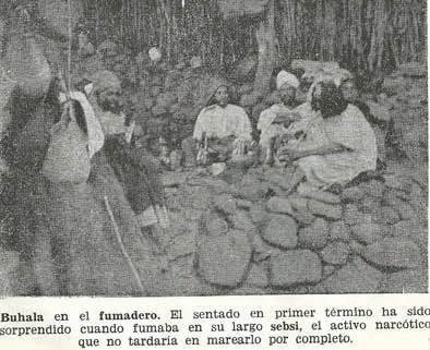 Grainy black-and-white historical photograph of men gathered in a smoking room, with a long sebsi pipe held by a seated man in the foreground and an original Spanish caption below.