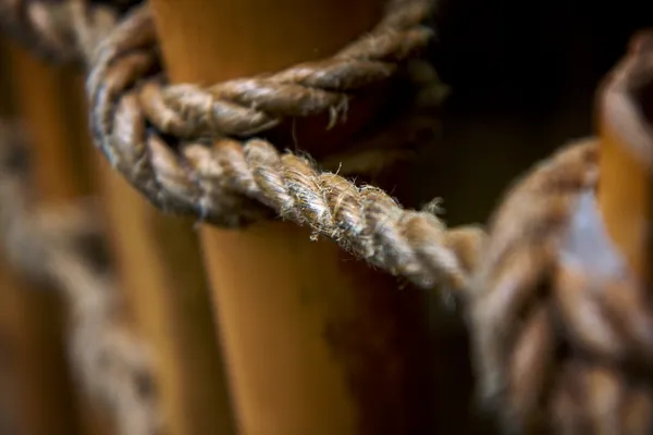Close view of twisted brown hemp rope with loose fibres along its strands