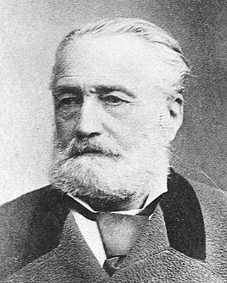 Black-and-white photograph of an elderly man with a white beard and swept-back hair