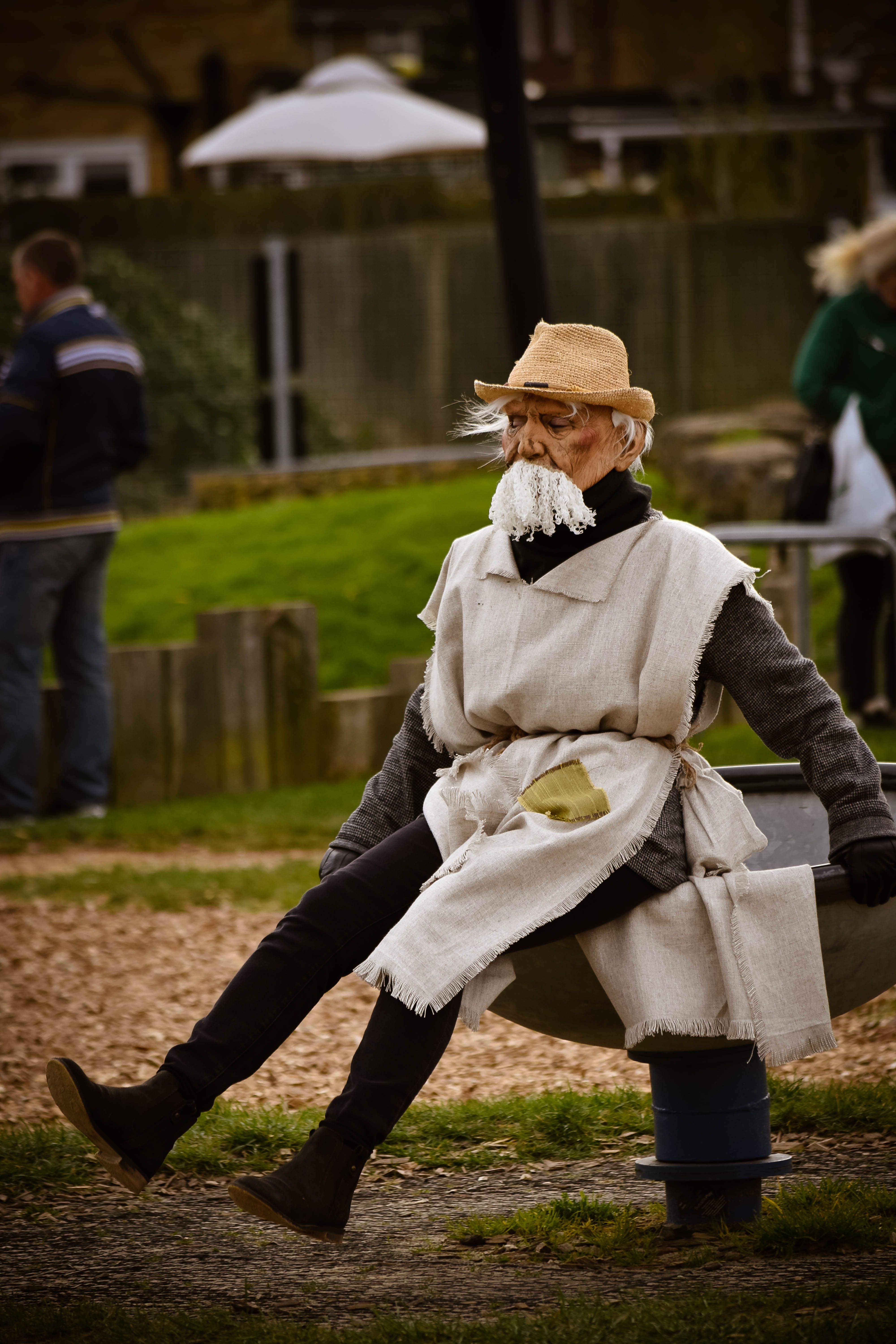 Traditional Lithuanian Hemp Man character wearing a straw hat, long white beard, and rough linen clothing during an Užgavėnės celebration.