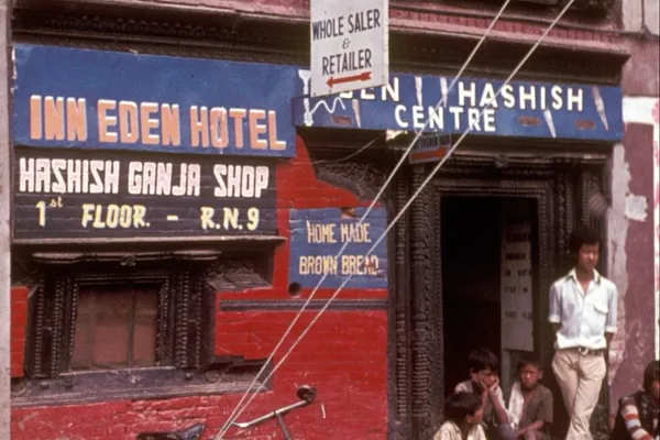 Customers sit outside Kathmandu's Eden Hashish Centre beneath signs advertising hashish, ganja and lodging