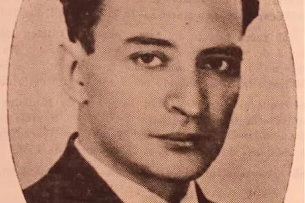 Oval sepia portrait of a young man with dark wavy hair in a suit and tie