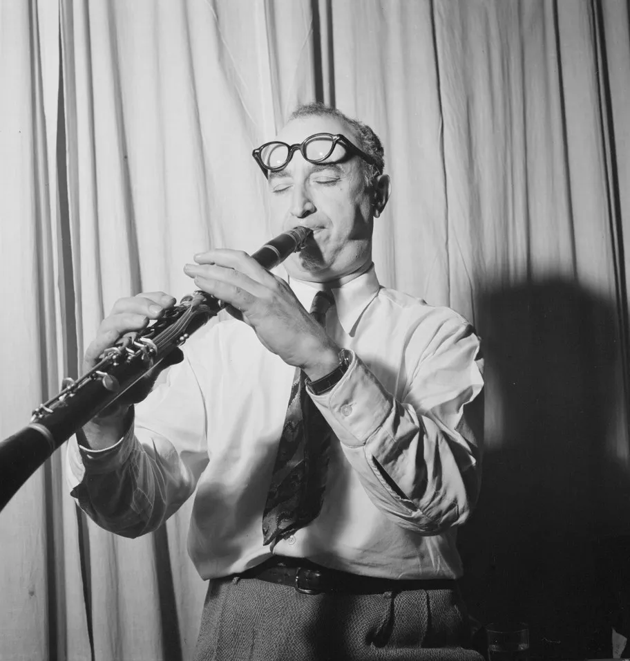 Mezz Mezzrow seated at a desk in his office