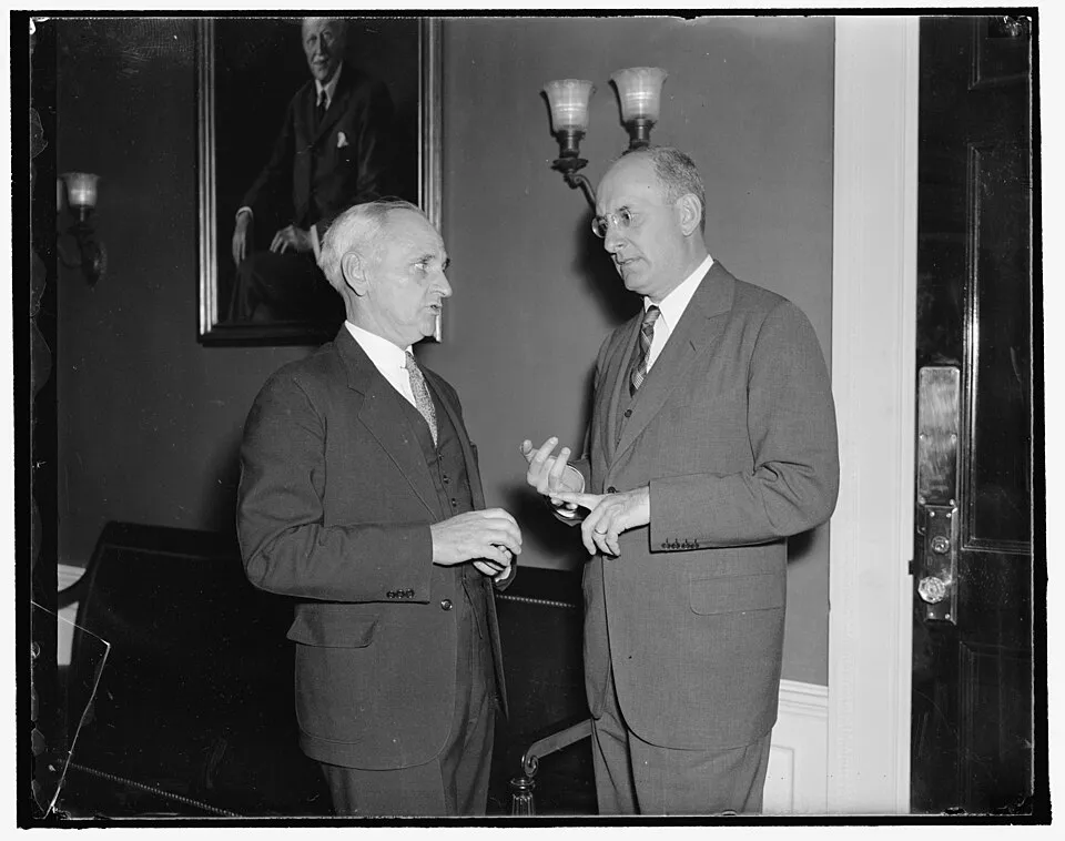 Two men in suits talking in an office