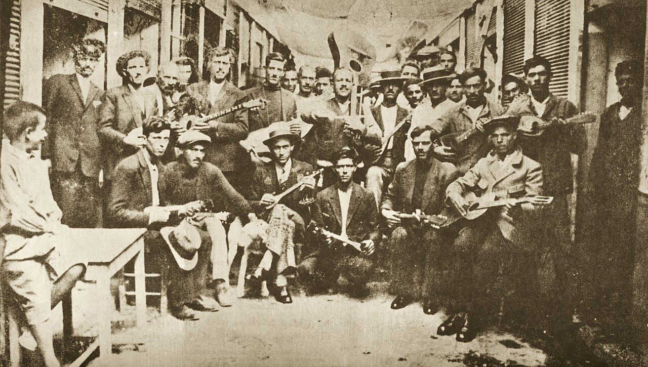 Four rebetiko musicians posed with bouzouki and guitar