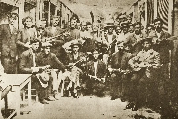 Four rebetiko musicians posed with bouzouki and guitar