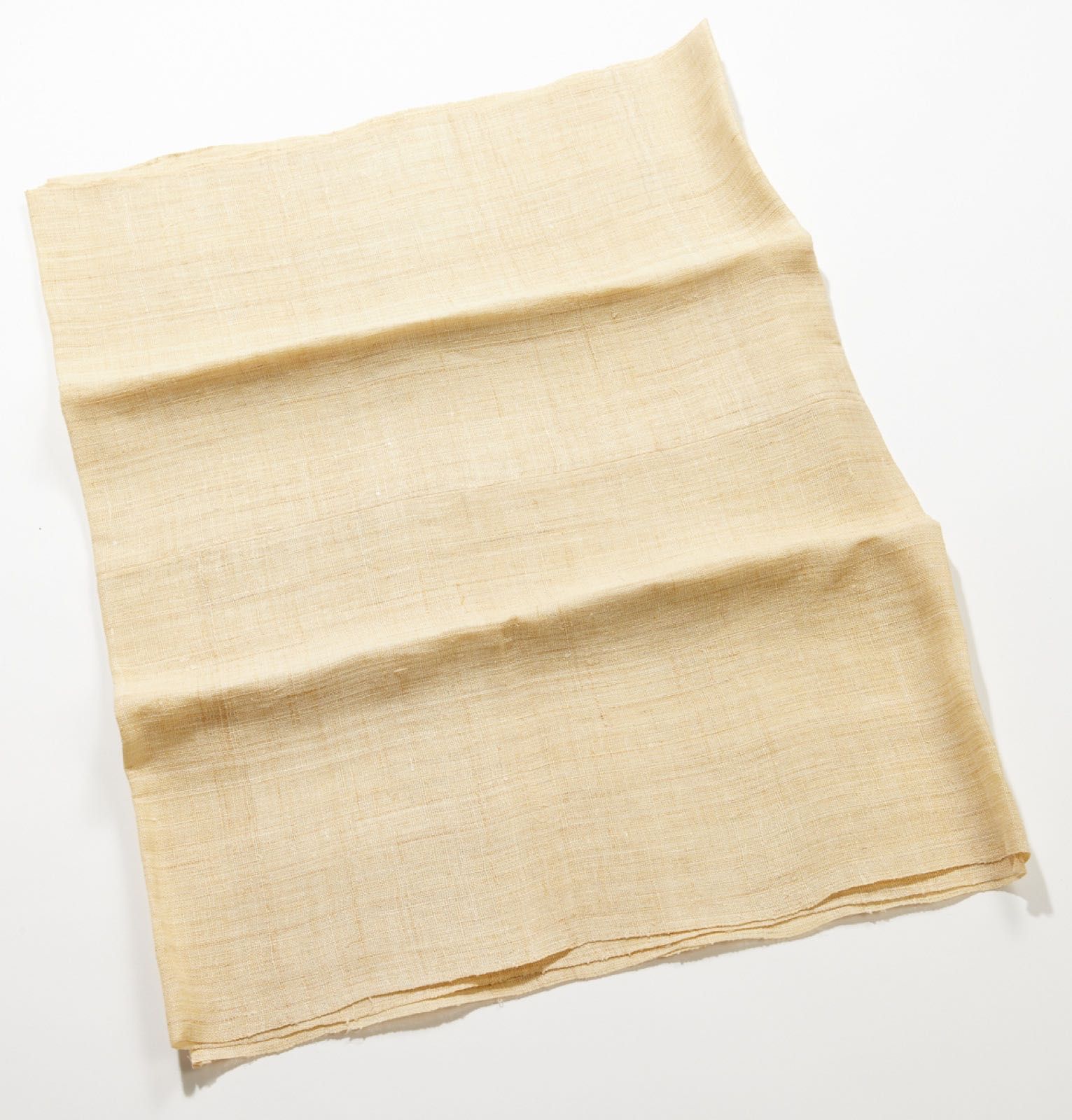 A folded length of coarse, pale yellow hemp cloth