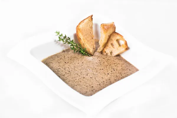 Traditional Silesian hemp-seed soup in a white bowl, served with toasted bread.