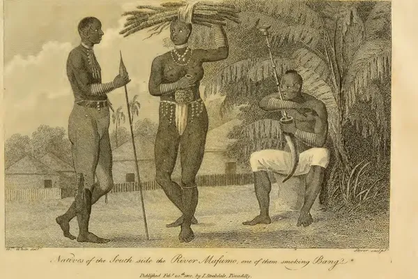 Engraving of three people outside thatched huts; on the right a seated man draws smoke from a large horn water pipe held in the crook of his arm, its long stem rising above his head.